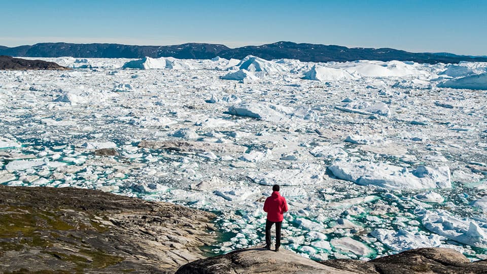 A man standing on a melting glacier